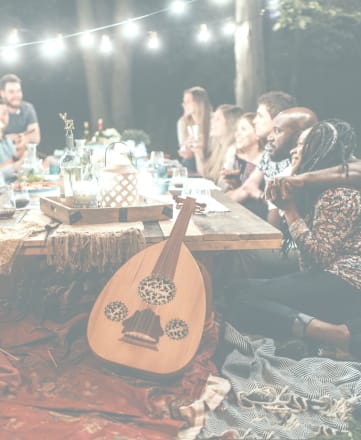 a group of people sitting around a table with a guitar