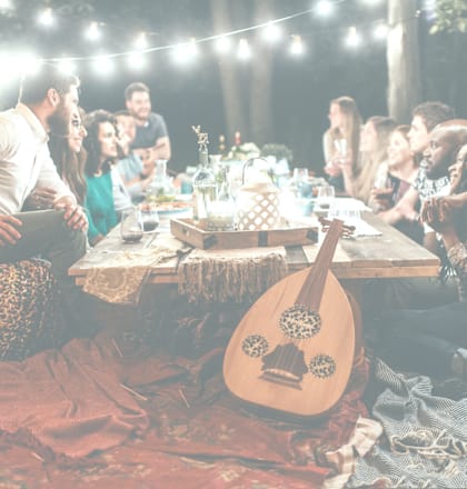 a group of people sitting around a table with a guitar