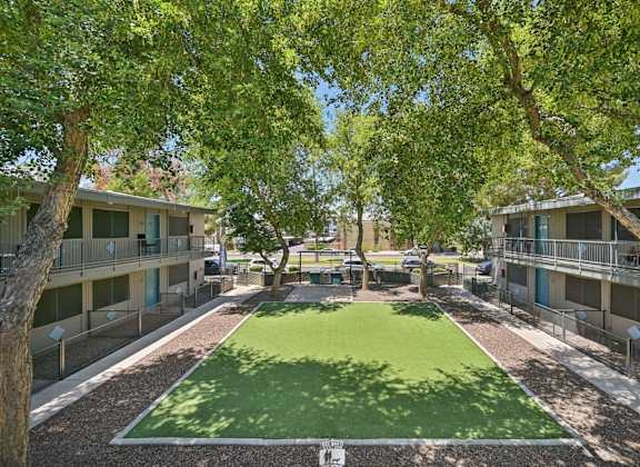 A green lawn in the middle of apartment buildings.