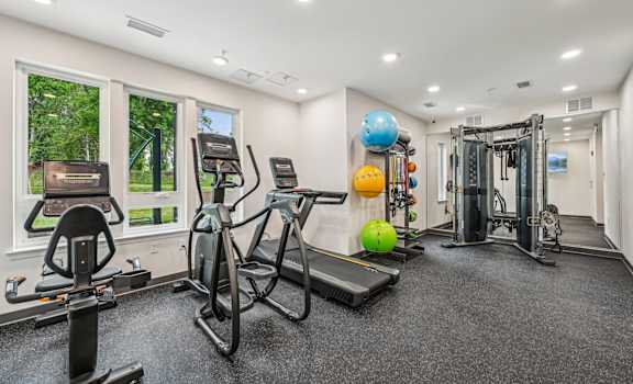 A spacious gym with a variety of equipment including treadmills, exercise bikes, and weight machines.