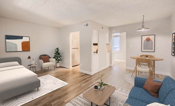 a bedroom and living room with hardwood floors and white walls