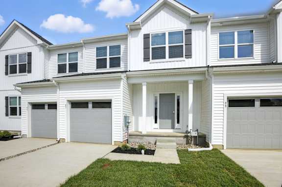 A white house with a grey garage door.
