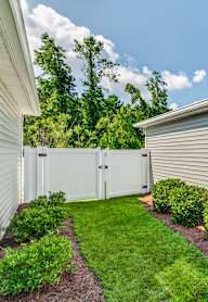 A house with a green lawn and a white fence.