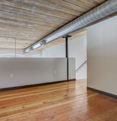 a large room with wood floors and white walls
