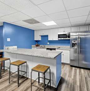 A kitchen with a bar area and stools at Avondale Overlook Apartments in Hyattsville, MD 20782