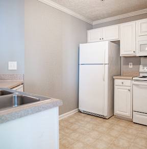A kitchen with white appliances and a countertop.