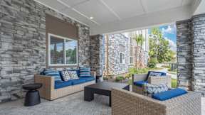 A patio with a couch, table and chairs.