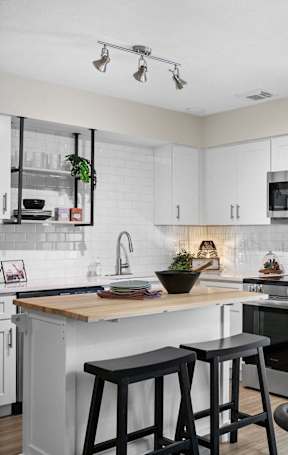 A kitchen with a red rug on the floor.
