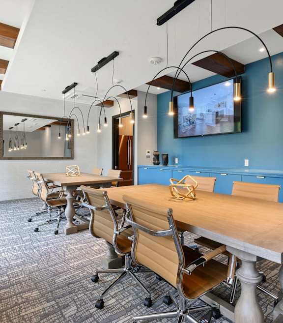 A conference room with a long table and chairs.