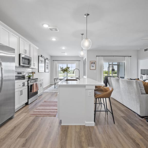 an open kitchen and living room with stainless steel appliances