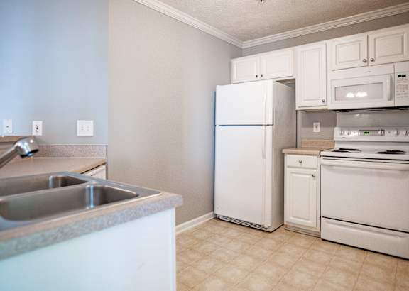 A kitchen with white appliances and a countertop.