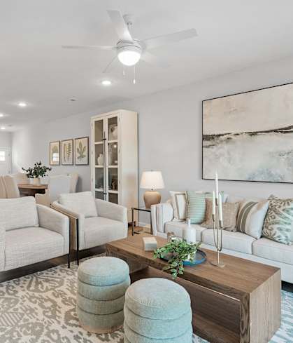 A living room with a white couch, a coffee table, and a rug.