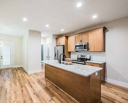 A kitchen with wooden cabinets and a granite countertop.