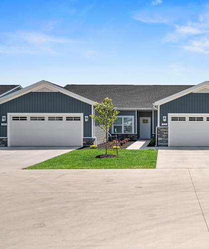 the front of a house with two garage doors and a driveway
