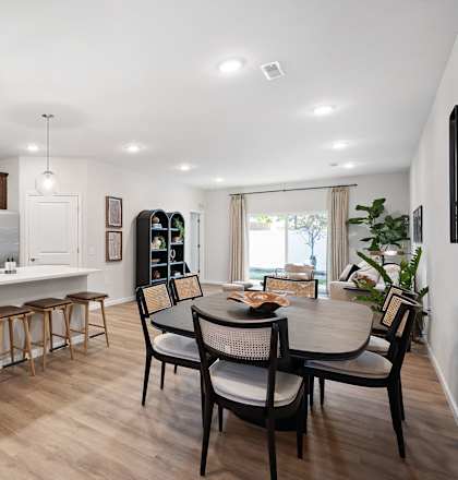 A modern kitchen with a dining table and chairs.