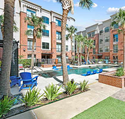 A pool surrounded by palm trees and chairs.