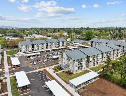A large apartment complex with a parking lot in front.