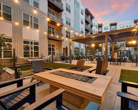 an outdoor patio with tables and chairs at an apartment complex