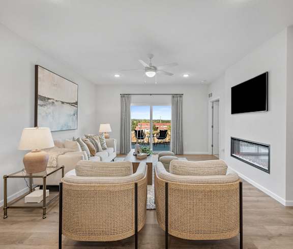 a living room with a couch and chairs and a ceiling fan