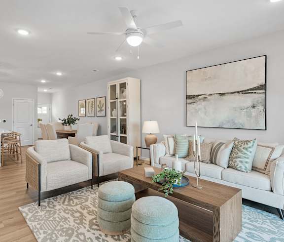 A living room with a white couch, a coffee table, and a rug.
