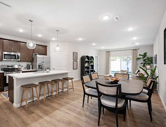 A modern kitchen with a dining table and chairs.