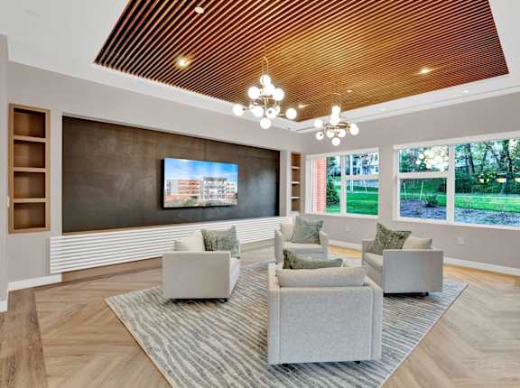 A living room with a grey sofa and a wooden ceiling.