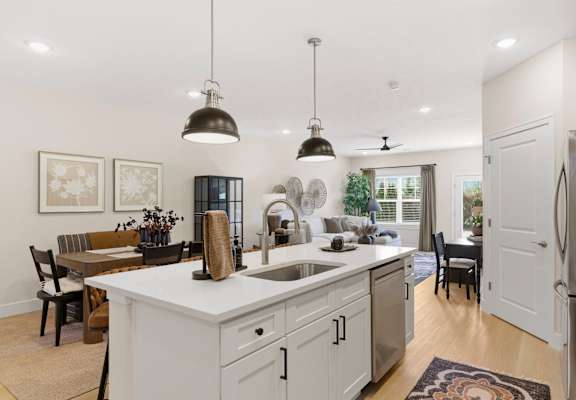 A kitchen with a white countertop and a sink under a window.