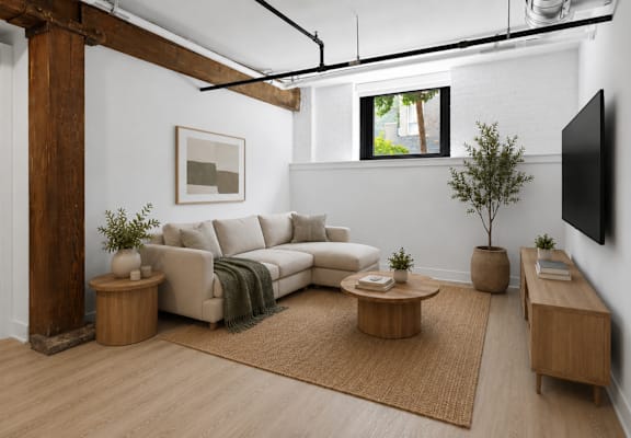 A living room with a white couch and a brown rug.