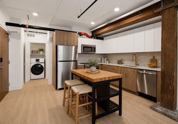 A kitchen with a wooden table and chairs.