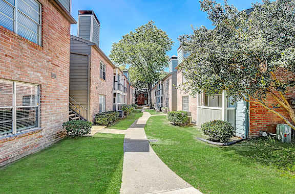 A row of houses with a sidewalk in between.
