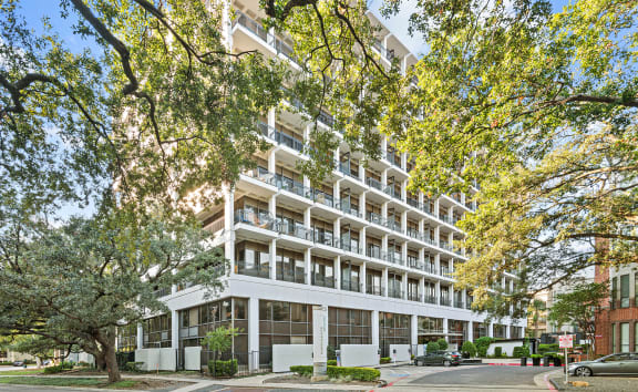 an apartment building on a city street with trees