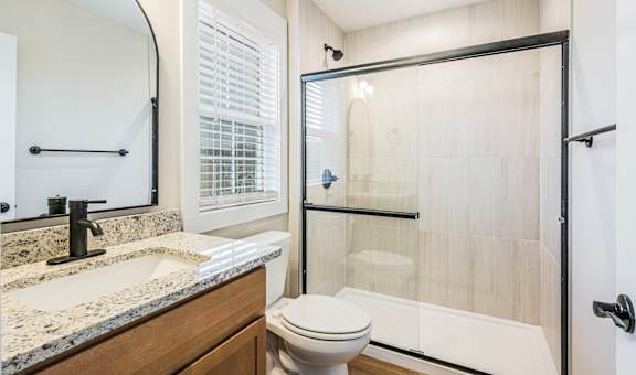 A bathroom with a toilet, sink, and shower.