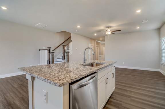A kitchen with a granite countertop and stainless steel appliances.