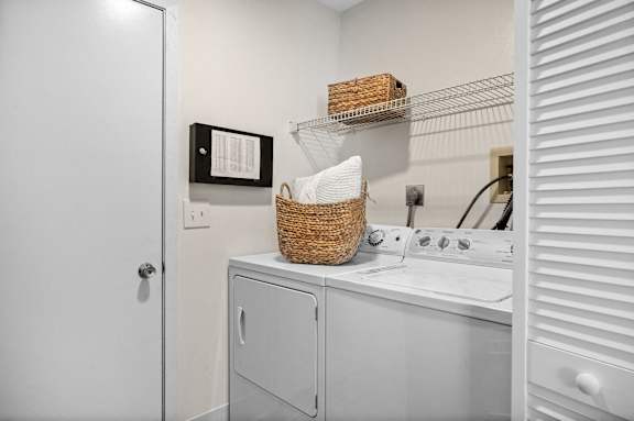 A white laundry room with a washer and dryer.