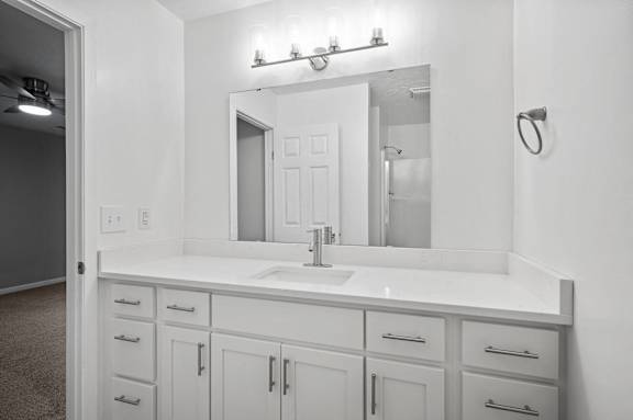 A bathroom with a sink and mirror.