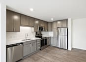 Thumbnail 19 of 22 - A modern kitchen with stainless steel appliances and wooden cabinets.