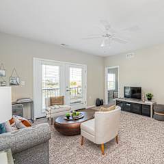 a living room with furniture and a ceiling fan