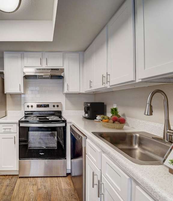 a kitchen with stainless steel appliances and white cabinets