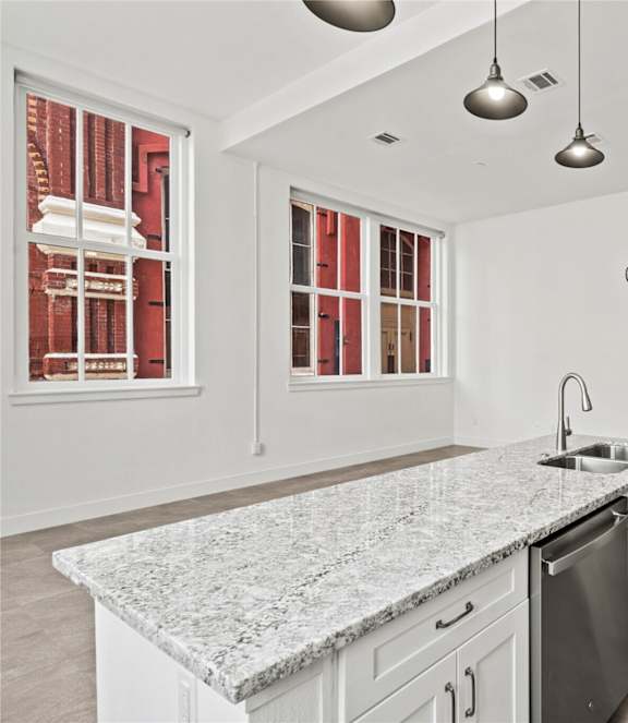A kitchen with a granite countertop and stainless steel appliances.