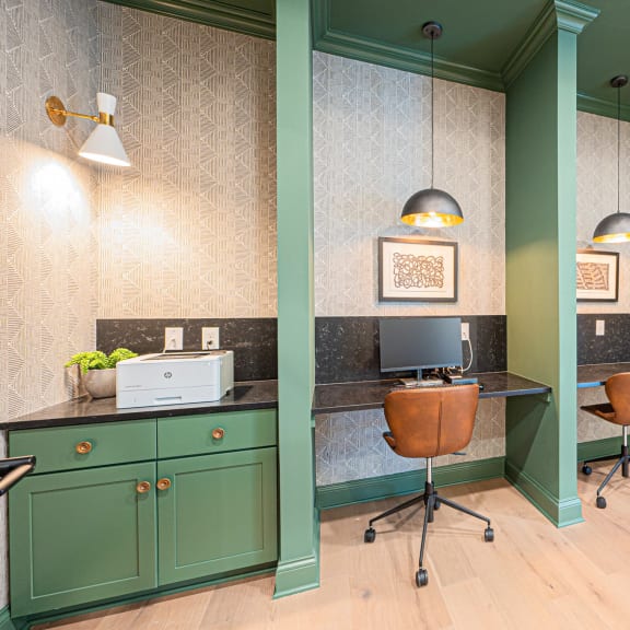 a home office with green cabinets and a desk with a computer