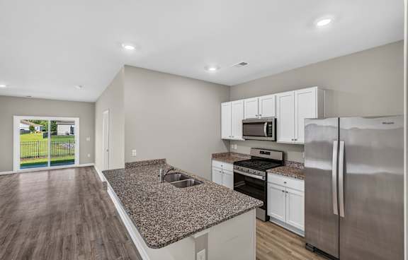 A kitchen with a granite countertop and stainless steel appliances.