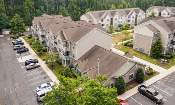 an aerial view of a large housing complex with cars parked in the parking lot