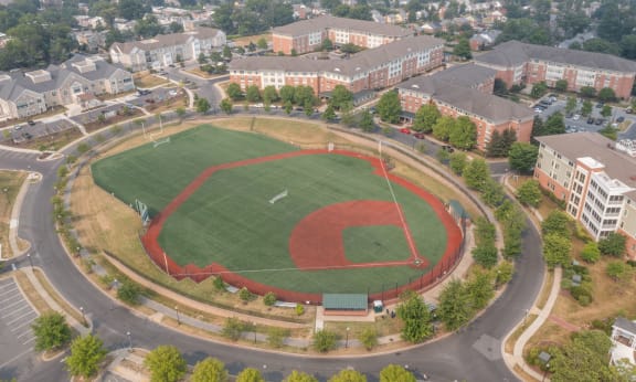 an aerial view of a baseball field with buildings in the background