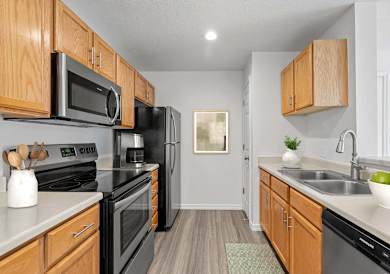 A kitchen with wooden cabinets and black appliances. at Eagles Landing, Ammon, ID, 83406