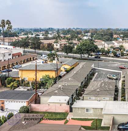 A parking lot with cars and a building in the background.