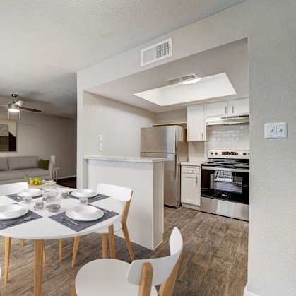 a living room and dining room with a white table and chairs