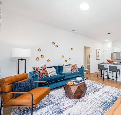a living room with a blue couch and a kitchen with a counter