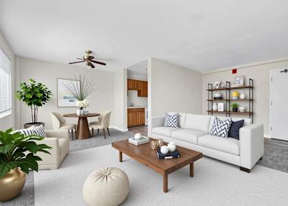A living room with a white couch, a coffee table, and a ceiling fan at Highland Ridge Apartments, Capitol Heights
