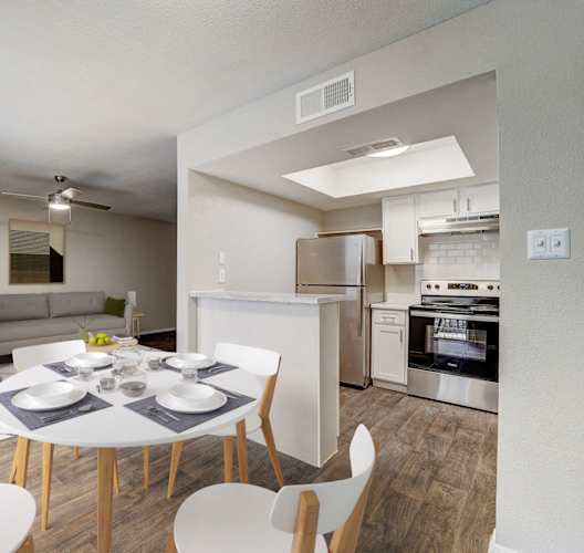 a living room and dining room with a white table and chairs