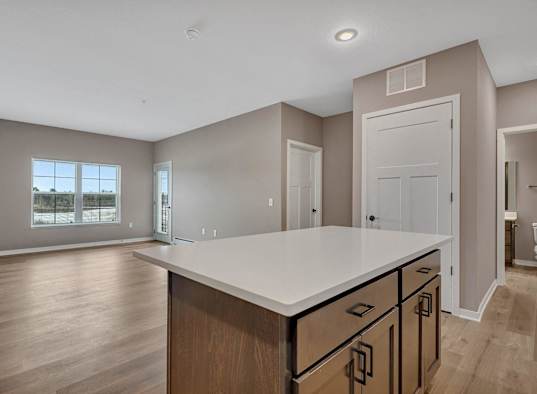 A kitchen with a large island and wooden cabinets.